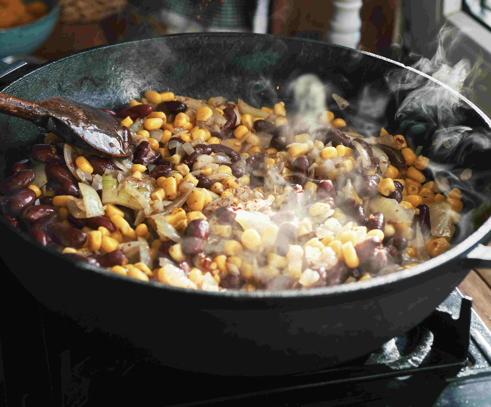 Corn and beans being cooked together in a pan.